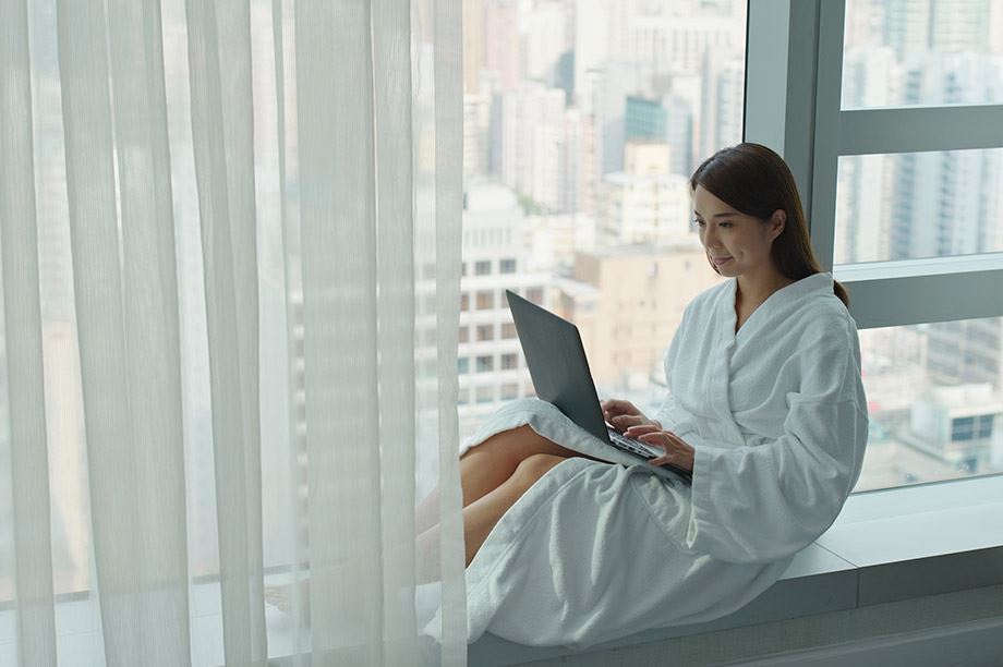 mujer trabajando con portátil en un hotel con vistas