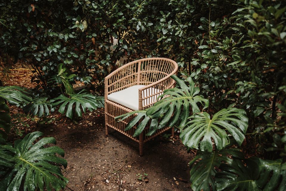 silla en una terraza con piscina y muchas plantas